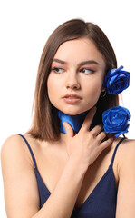 Wall Mural - Beautiful young woman with blue roses on white background