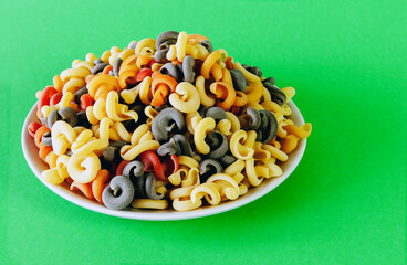 Italian green multicolored pasta with tomato and basil flavor on a plate