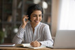 © fizkes - Close up Indian woman in headphones writing taking notes, watching webinar or listening to lecture, looking at laptop screen, happy young female student involved in online course, studying at home