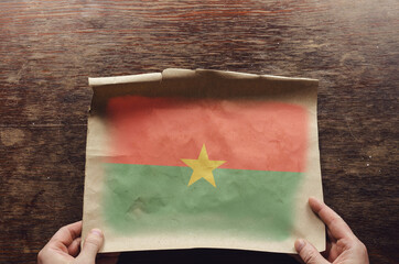 Wall Mural - The national flag of Burkina Faso on a torn piece of paper.