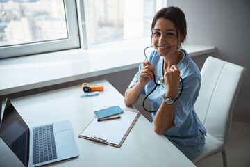 Wall Mural - Cheerful female doctor working in modern clinic