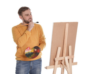 Poster - Man painting with brush on easel against white background. Young artist