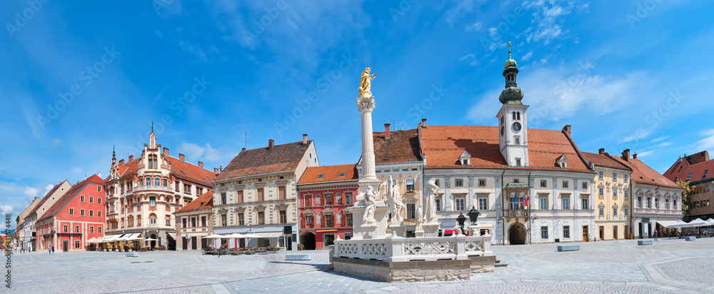 Banner, Maribor city center in Slovenia. Town Hall and Plague Monument on the Maribor Main Square. Blue sky, bright daylight, panoramic cityscape. Famous tourist destination in Europe. - obrazy, fototapety, plakaty 