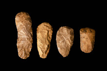 Four Stone Age Neolithic Adzes. Belonging To The Acheulean Culture. Handle Tools. Of Flint. Used For Manual Digging. Located In The Sahara Desert. Black Background