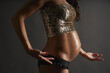 Young Hispanic pregnant ballerina posing with a sequin top and black underwear in studio