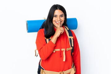 Wall Mural - Young Colombian mountaineer girl with a big backpack isolated on white background doing silence gesture