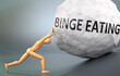 Binge eating and painful human condition, pictured as a wooden human figure pushing heavy weight to show how hard it can be to deal with Binge eating in human life, 3d illustration