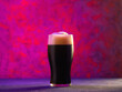 A glass of craft dark beer stout or porter on a creative bright background. Stylish Light