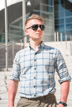 A Young Blond Man In Sunglasses Stands On The Steps Of The Walt Disney Concert Hall. Business Style In A Trendy Building, Los Angeles