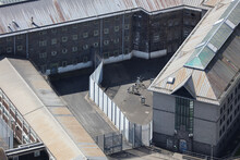 An Aerial View Of A HMP Prison Taken From A Helicopter In The United Kingdom. The Old Grey Her Majesties Prison Has Fences And Barbed Wire Preventing The Escape Of The Jails Inmates