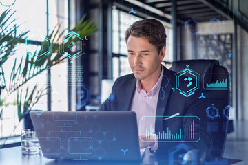 handsome businessman in suit at workplace working with laptop to optimize development by implying ne