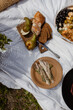 picnic on a white picnic blanket. sliced pear, sliced bread and basket shade. wooden cutlery for a picnic. outdoor picnic details.