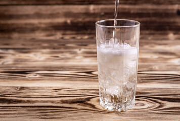 Wall Mural - fresh seltzer water is poured into a glass with ice