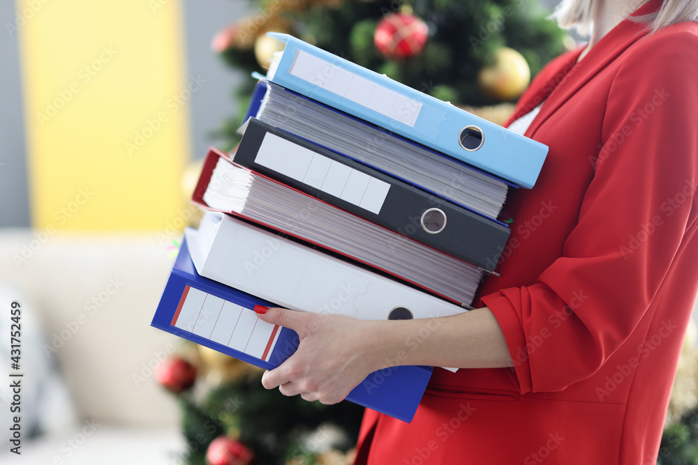 Woman is holding heavy stack of folders with documents. - obrazy, fototapety, plakaty 