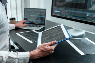 Wall Mural - young programmer working in software javascript computer in it office, writing codes and data code w