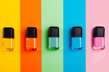 Group of vivid color nail polishes isolated on colorful background