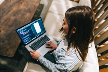 Young woman mobile developer with laptop, writes program code on a computer, programmer work in modern office.