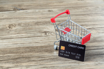 Shopping cart with credit card. Stay home shopping and electronic payment with credit card concept. Small shopping cart with credit card inside  is business on desk, concept use credit for shopping.