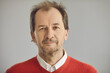 © Studio Romantic - Happy balding senior European man with friendly face expression looking at camera. Head shot portrait of mature businessman, school teacher or college or university professor on grey studio background
