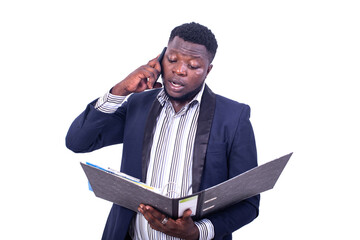 serious young businessman checking reports on document in filing cabinet and talking on mobile phone