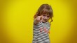 © Andrii Iemelianenko - You and me here and right now. We are team. Little child girl looking authoritative, fingers down, demanding immediate serious conversation, giving command. Kid children on yellow studio background