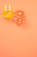 Sticker - Vertical shot of yellow and red dice on a pastel orange background