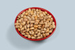 Dry pinto bean seed in red plastic bowl