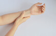 © hippomyta - Hand massaging arm wrist with visible blood vessel in white background