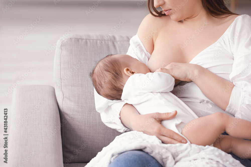 Young woman breastfeeding her baby at home