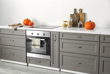 Modern furniture with oven near white wall in kitchen