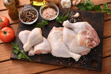 Fresh Raw Chicken Thighs With Ingredients For Cooking On A Wooden Cutting Board
