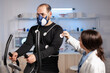 © DC Studio - Man athlete with mask running on cross trainer after medical researcher attached electrodes to her body. Physician using computer to controls EKG data showing on laboratory monitors, VO2 max test.