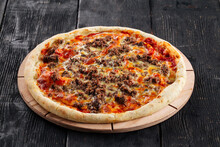 Pizza with minced meat and tomato sauce on the dark wooden background