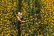 © Bits and Splits - Aerial view of female farmer with tablet computer in rapeseed field using innovative technology
