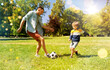 © Syda Productions - family, fatherhood and people concept - happy father and little son with ball playing soccer at summer park