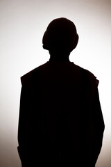 Wall Mural - dark silhouette of young engineer in hard hat on white isolated background, building industry concept