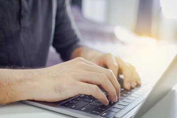 Wall Mural - Close-up shot  Man is using laptop keyboard to work at home , Business investment-finance accounting concept