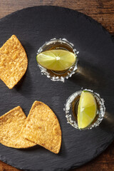 Wall Mural - Golden tequila with lime slices and nacho chips