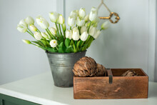 Composition Of Dried Artichoke Flowers In Wooden Box And A Bouquet Of White Tulips In A Vase As Home Decoration. Modern Style Flowers Arrangement In Home. Decor Of Dry Flowers Home. Mothers Day	
