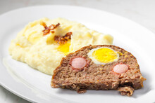 Meat Loaf Filled With Egg And Sausage Served With Mashed Potatoes And Fried Onion