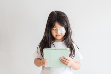 lazy eye amblyopia in children.eye care.little asian girl covered up with a special patch online lea