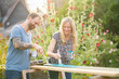 © Annika List/Westend61 - Couple painting wooden plank in garden
