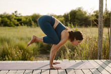 Mid Adult Woman Doing Handstand Yoga Position At Gazebo
