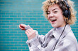 © Angel Santana Garcia/Westend61 - Cheerful woman dancing while listening music through headphones