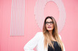 © David Ag√ºero Mu√±oz/Westend61 - Beautiful young woman against pink wall looking away