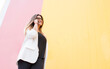 © David Ag√ºero Mu√±oz/Westend61 - Smiling young woman talking on phone against pink and yellow wall