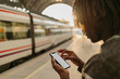 © Gerard Moral Casanovas/Westend61 - Young man using smart phone while waiting at railroad station