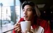 © Jose Carlos Ichiro/Westend61 - Young man having coffee in cafe during winter