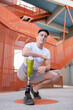 © Jose Carlos Ichiro/Westend61 - Handsome young amputated man crouching against orange staircase