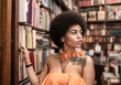 © Jose Carlos Ichiro/Westend61 - Thoughtful young woman looking away by bookshelf at library